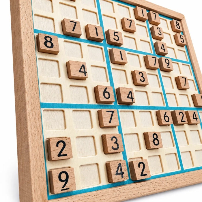 Zbliżenie drewnianej planszy sudoku z niebieską siatką i klockami z cyframi
